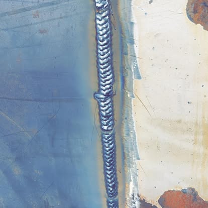 Close-up of a clean stacked-dime weld bead on steel plate